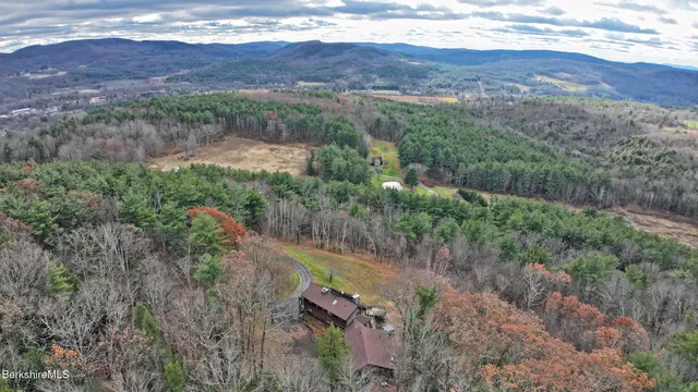 an aerial view of mountains with green space and fog