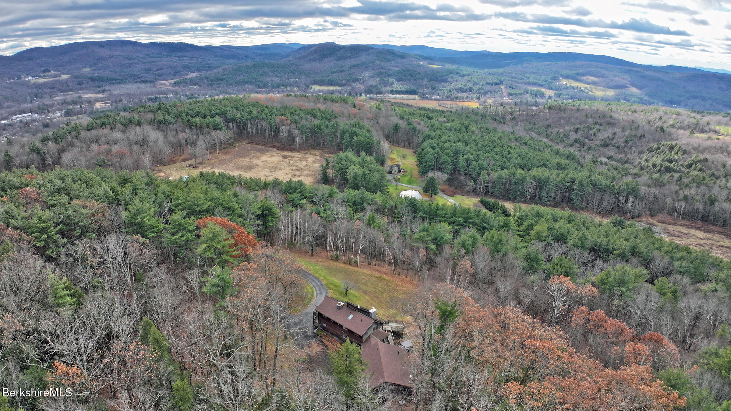 an aerial view of mountains with green space and fog
