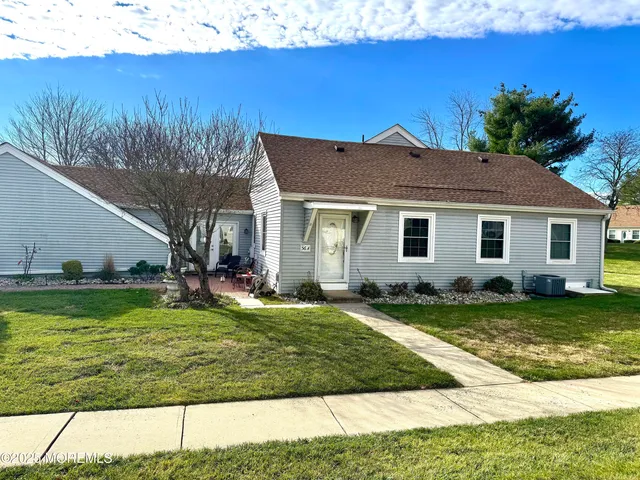 a view of a yard in front of a house with a large tree