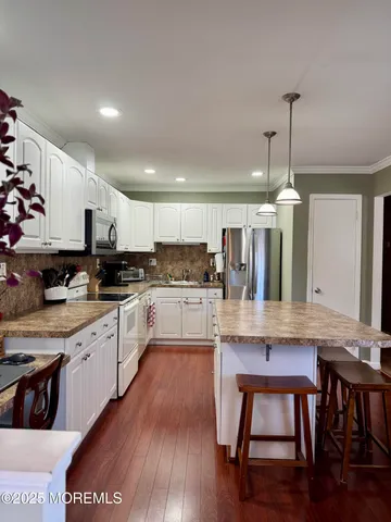 a kitchen with stainless steel appliances granite countertop a sink refrigerator and cabinets