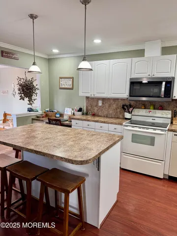 a kitchen with stainless steel appliances granite countertop a stove and a wooden floors
