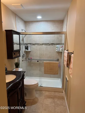 a bathroom with a granite countertop sink toilet mirror and shower
