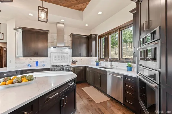 a kitchen with stainless steel appliances a stove a sink and a microwave