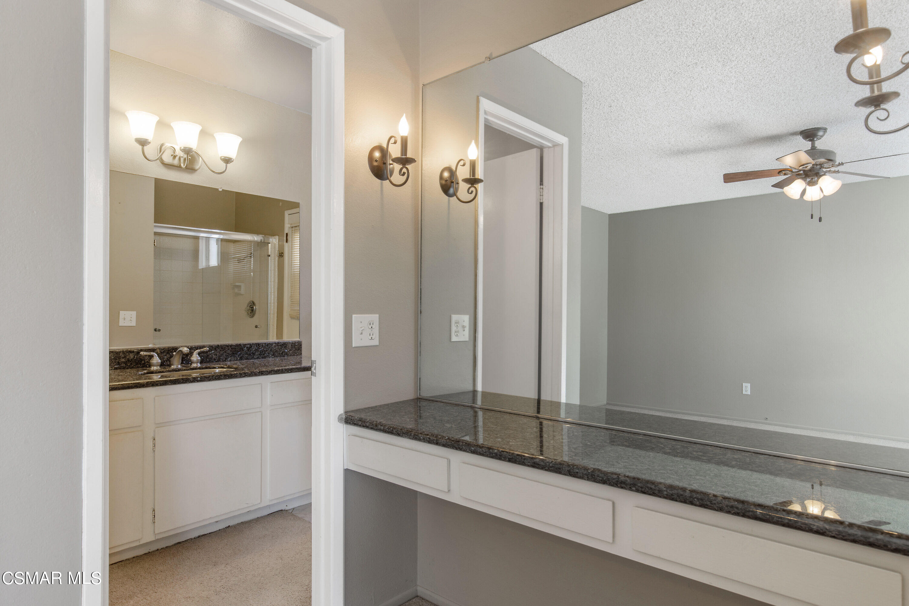 4262 Tecolote Court Moorpark, CA 93021 - Photo 16 of 32 a bathroom with a granite countertop sink a mirror and a shower
