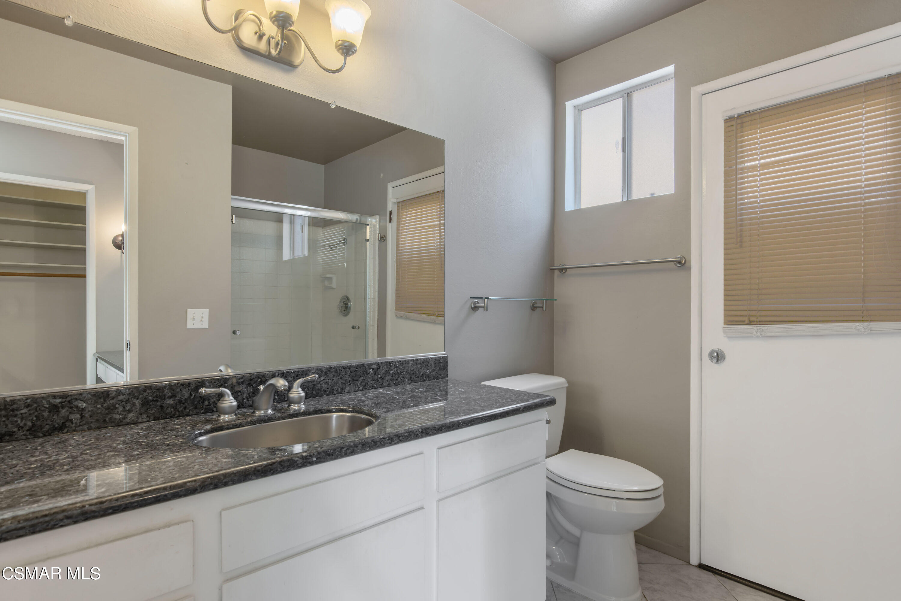 4262 Tecolote Court Moorpark, CA 93021 - Photo 17 of 32 a bathroom with a granite countertop sink a toilet and a mirror