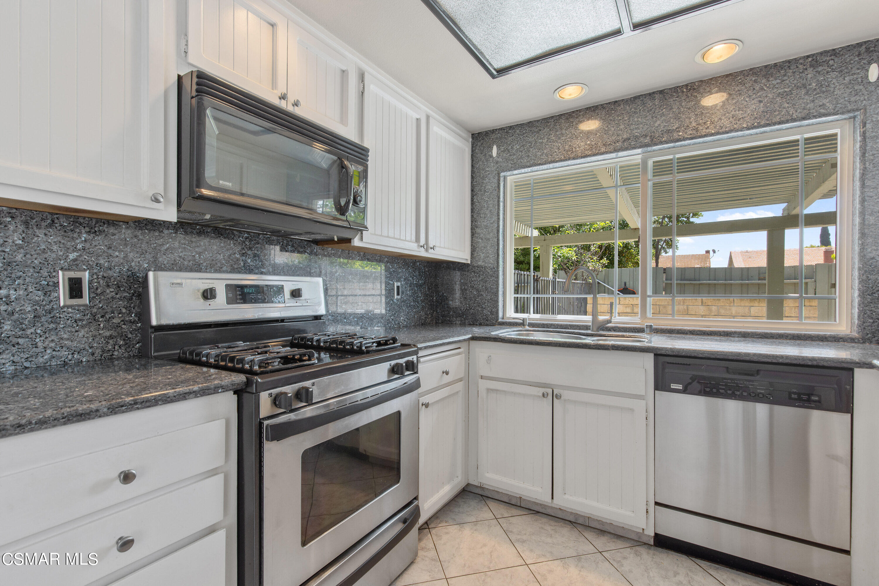 4262 Tecolote Court Moorpark, CA 93021 - Photo 9 of 32 a kitchen with white cabinets and appliances