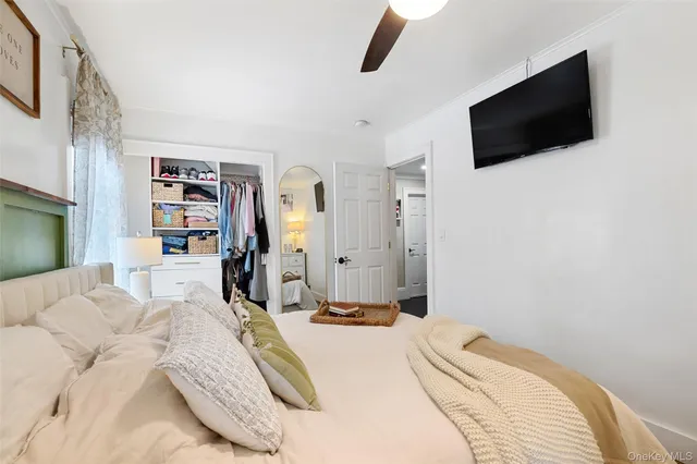 a bedroom with a bed a flat screen tv and view