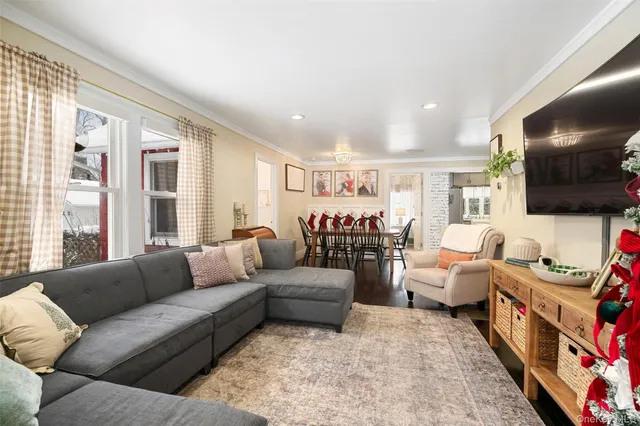 a living room with furniture flat screen tv and a large window