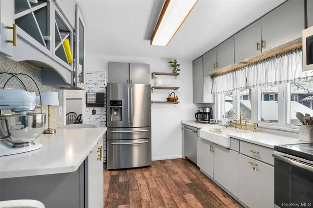 a kitchen with stainless steel appliances a sink a stove a refrigerator and cabinets