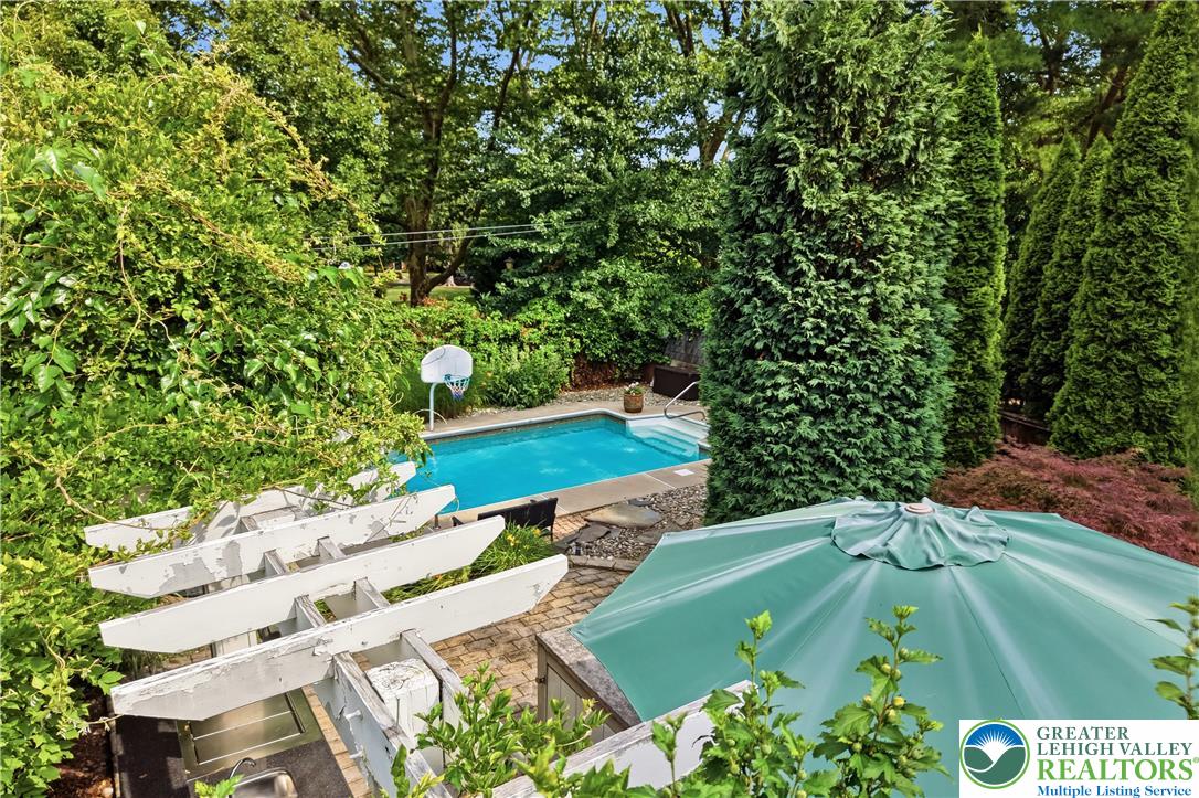 2014 Linden Street Bethlehem, PA 18017 - Photo 71 of 85 An inviting private outdoor space with an in-ground pool, surrounded by lush, mature landscaping and a pergola.