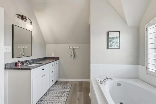 a bathroom with a bathtub sink and mirror