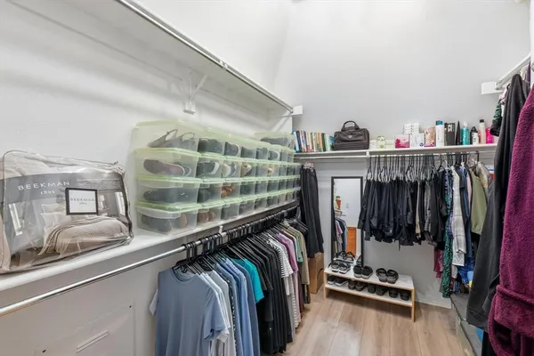 a view of walk in closet with clothes and shoes