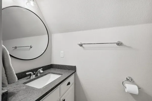 a bathroom with a granite countertop sink a mirror and a vanity