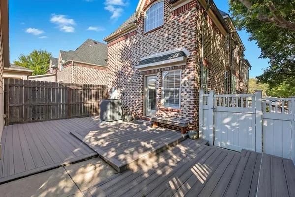 a view of a deck with wooden floor and fence with a bench