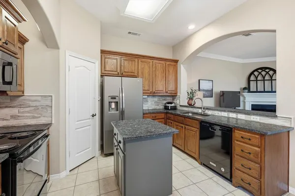 a kitchen with granite countertop a sink stove oven and refrigerator