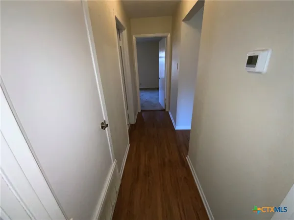 a view of a hallway with wooden floor