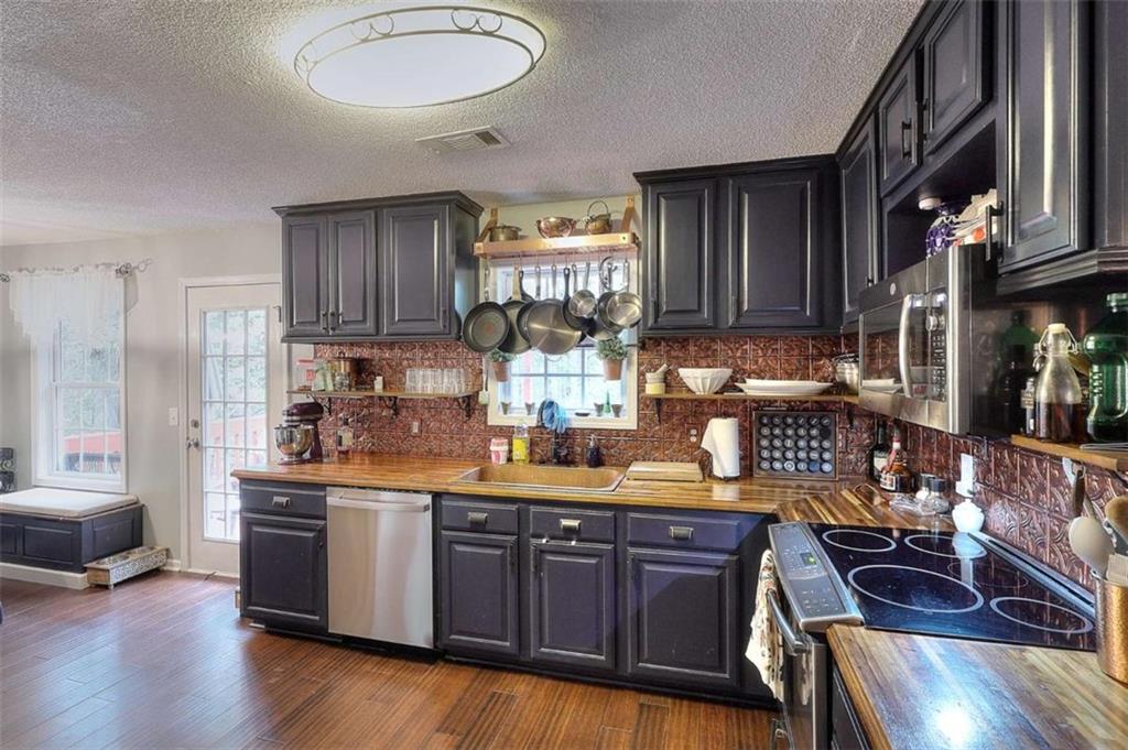 738 Worth Court Bethlehem, GA 30620 - Photo 4 of 43 a kitchen with stainless steel appliances granite countertop a sink dishwasher stove and cabinets