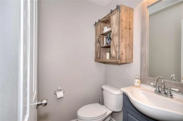 a bathroom with a toilet a sink and mirror