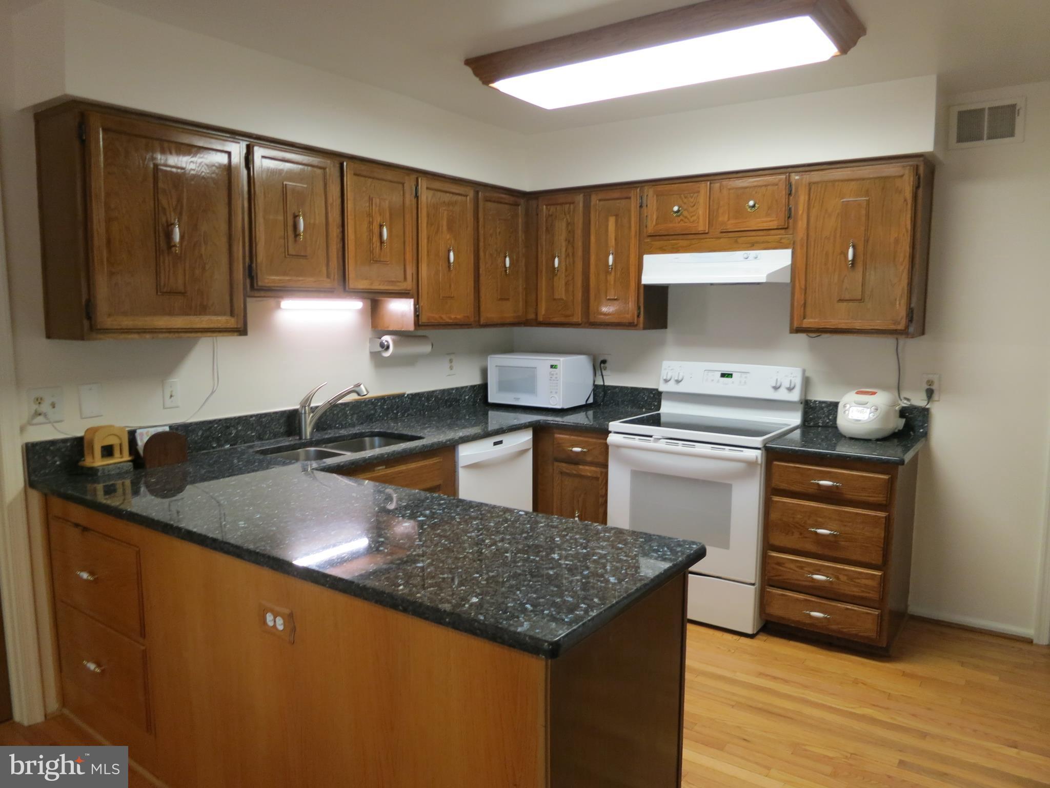9156 Rockefeller Lane Springfield, VA 22153 - Photo 9 of 30 a kitchen with granite countertop a sink stove and cabinets