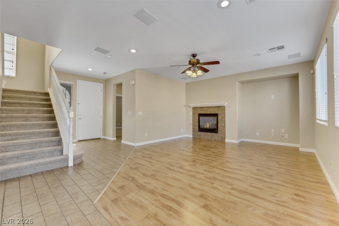 10328 Hawk Ravine Street Las Vegas, NV 89178 - Photo 6 of 55 A welcoming entry features a fireplace with a decorative mantel and warm wood-style flooring.