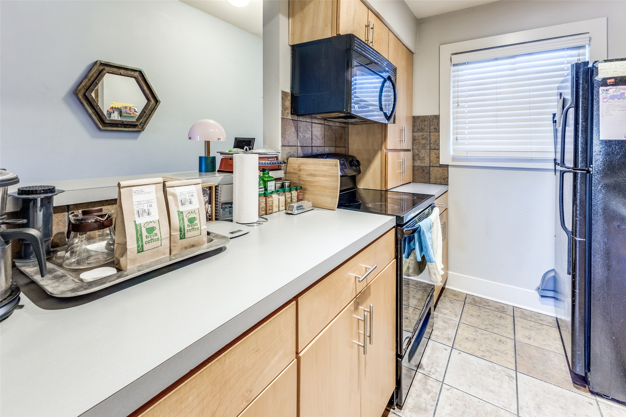 3815 Guadalupe Street, Unit 305 Austin, TX 78751 - Photo 11 of 27 a kitchen with stainless steel appliances granite countertop a sink and a refrigerator