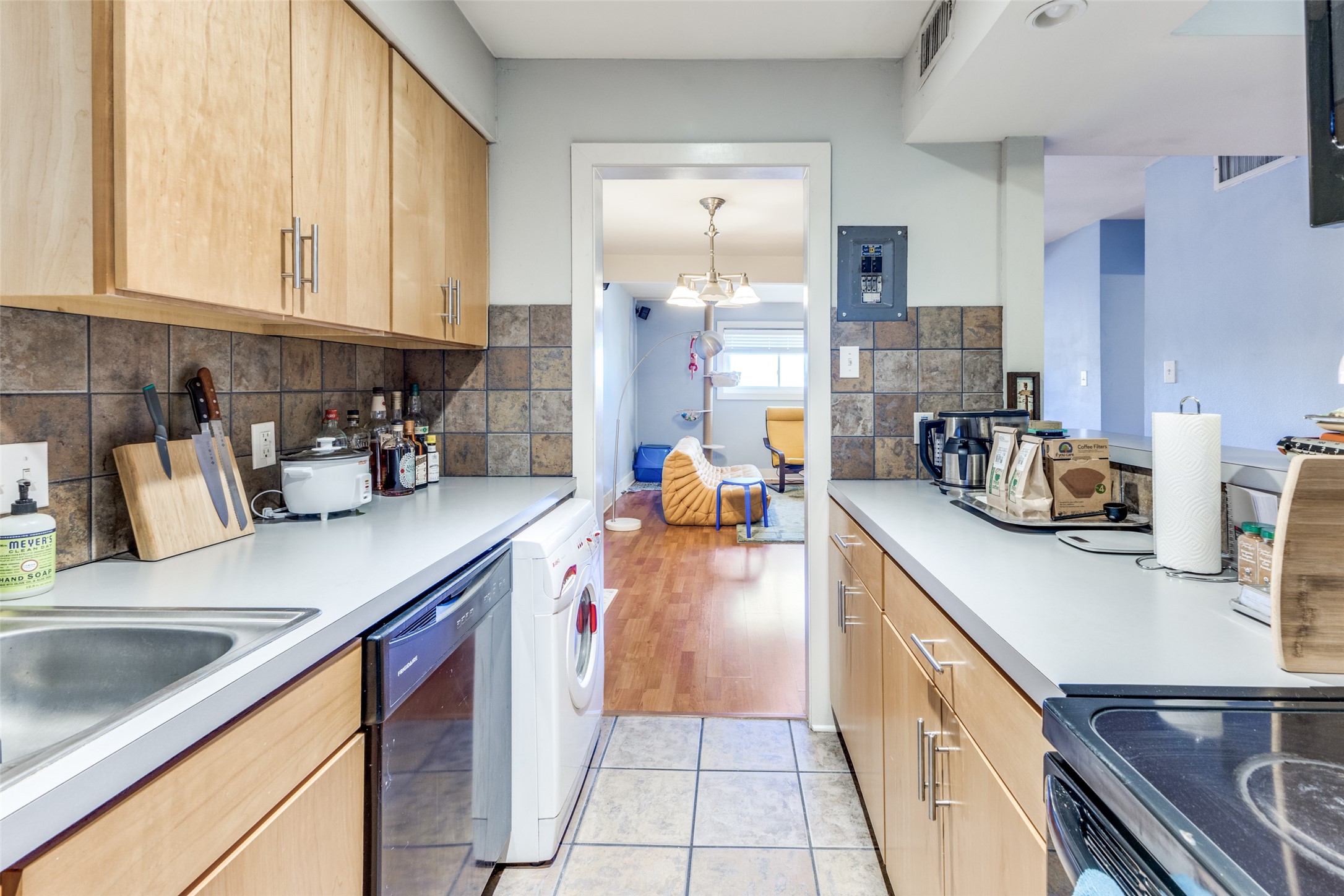 3815 Guadalupe Street, Unit 305 Austin, TX 78751 - Photo 12 of 27 a kitchen with stainless steel appliances granite countertop a sink counter space cabinets and a view of living room