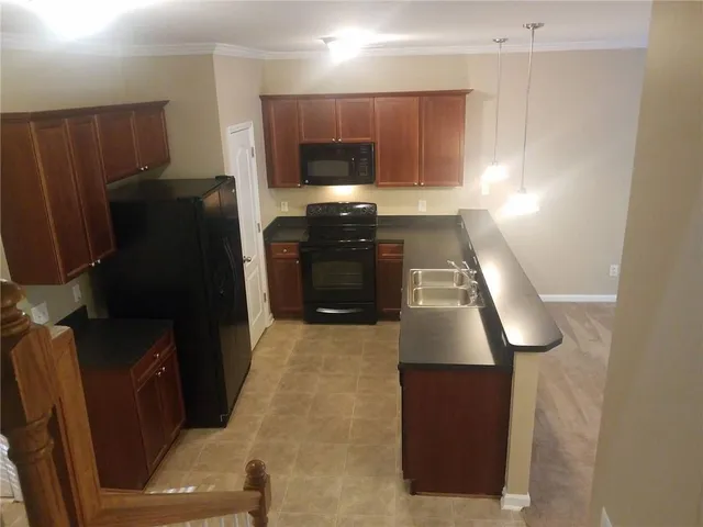a kitchen with granite countertop a refrigerator and a stove