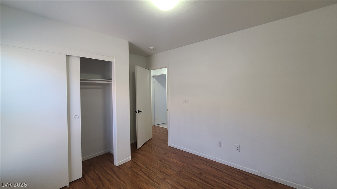 8944 Rutherford Grove Street Las Vegas, NV 89148 - Photo 27 of 35 A well-lit bedroom features rich wood flooring and a convenient sliding closet.