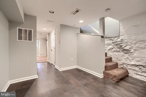 a view of a livingroom with wooden floor and kitchen space