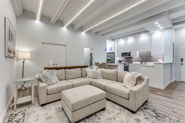 a living room with furniture and a view of kitchen
