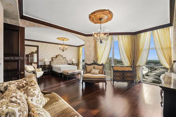 a bedroom with a large bed and a chandelier