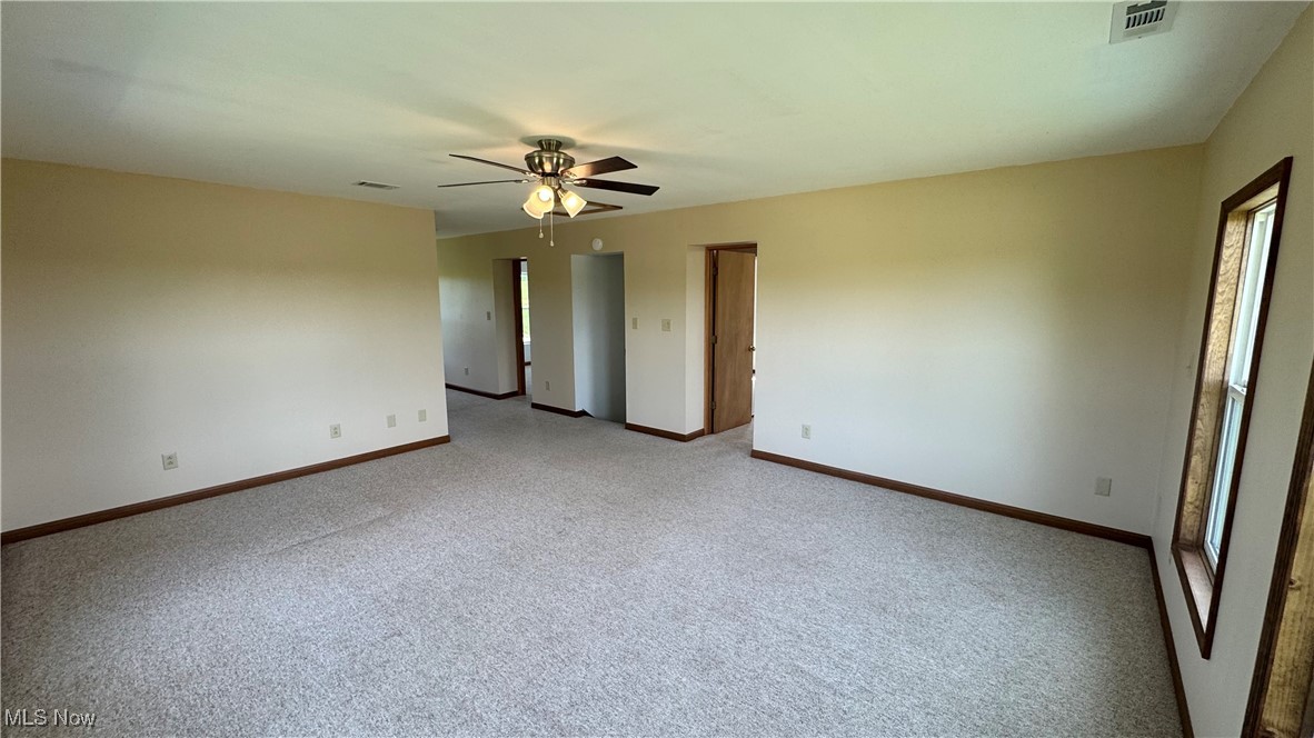 6255 Highland Ridge Road Lowell, OH 45744 - Photo 13 of 40 Unfurnished room with a ceiling fan, light carpet, and baseboards