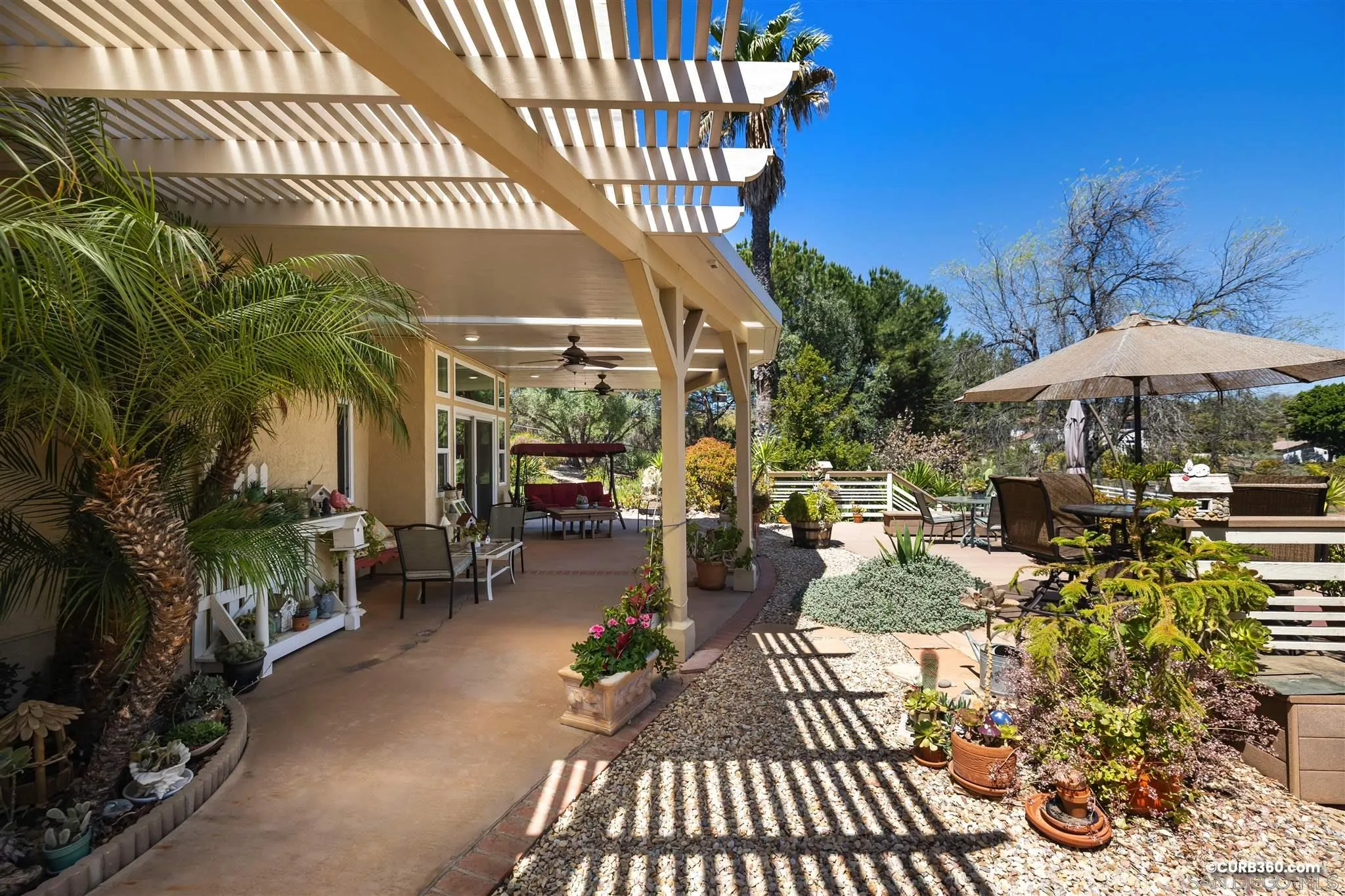 2520 Tompau Place Alpine, CA 91901 - Photo 30 of 41 a view of a patio with table and chairs under an umbrella with palm trees