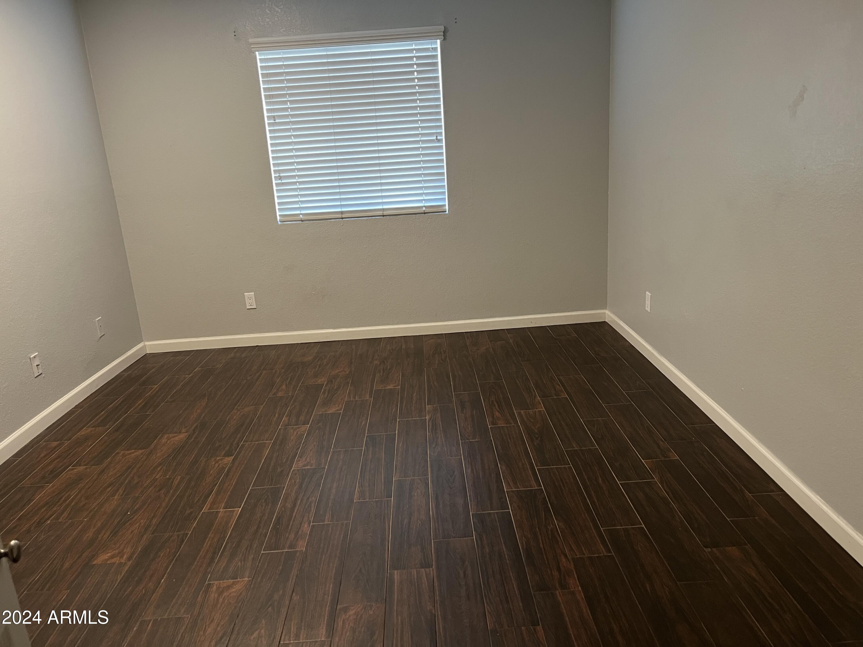 740 West Elm Street, Unit 110 Phoenix, AZ 85013 - Photo 12 of 22 a view of an empty room with wooden floor and a window