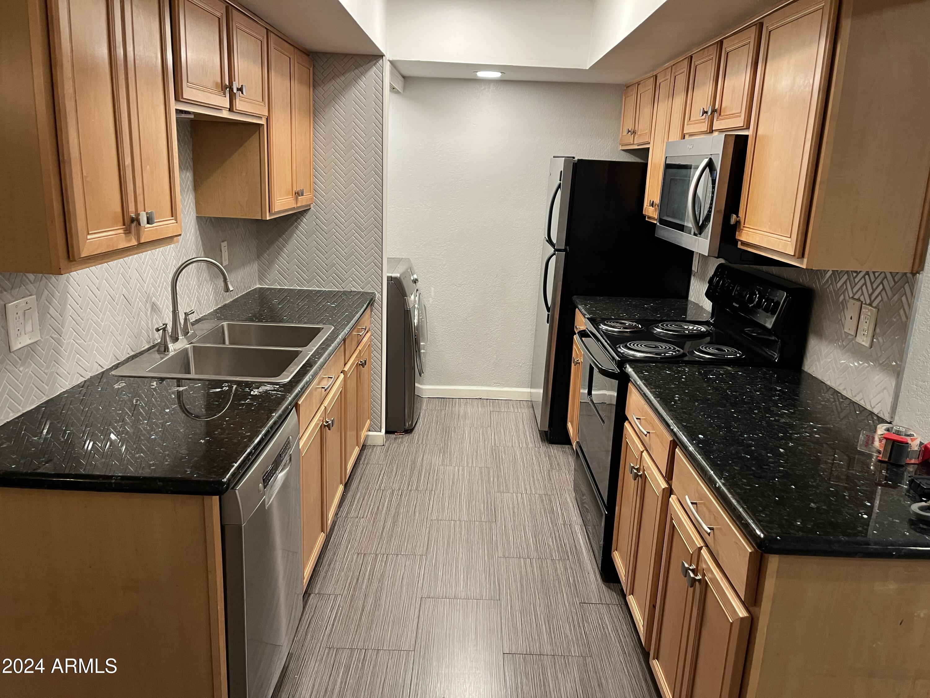 740 West Elm Street, Unit 110 Phoenix, AZ 85013 - Photo 4 of 22 a kitchen with granite countertop a sink stove and refrigerator