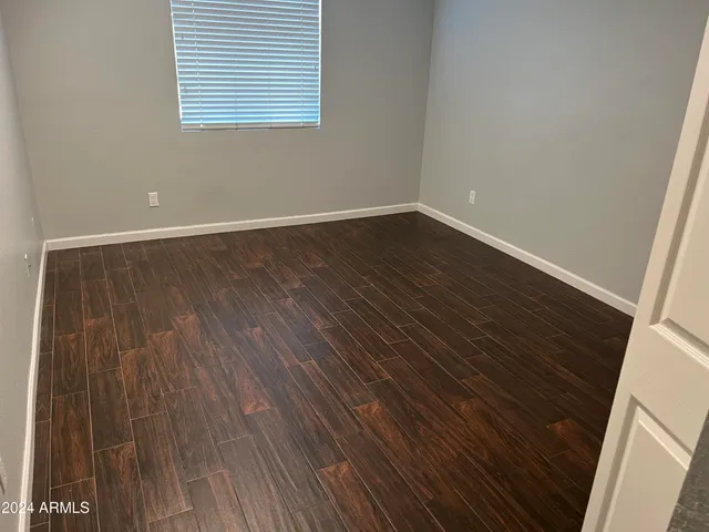 an empty room with wooden floor and door