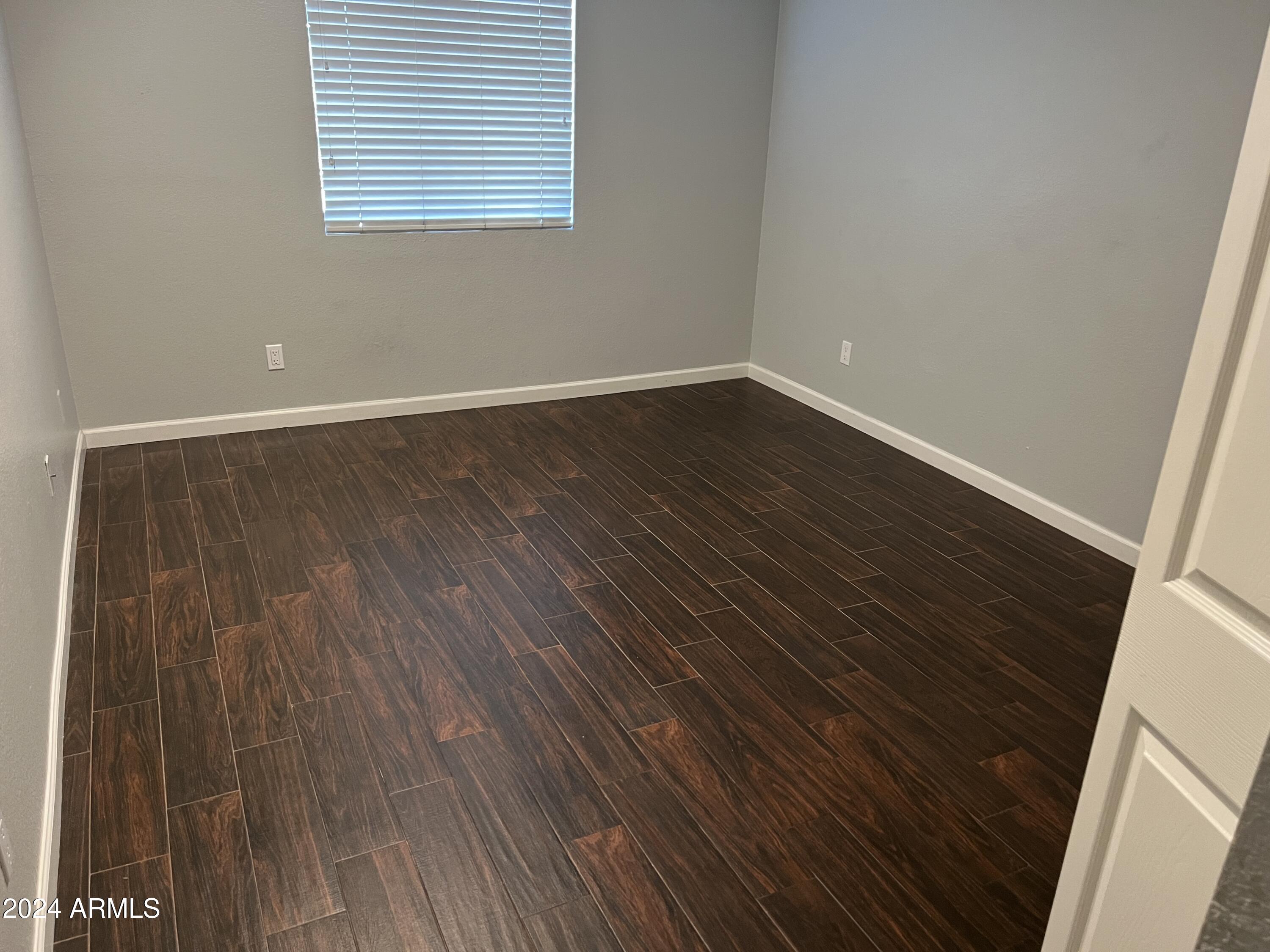 740 West Elm Street, Unit 110 Phoenix, AZ 85013 - Photo 10 of 22 a view of an empty room with wooden floor and a window