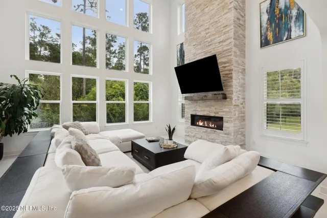 a view of a sign board with flower plants and wooden fence