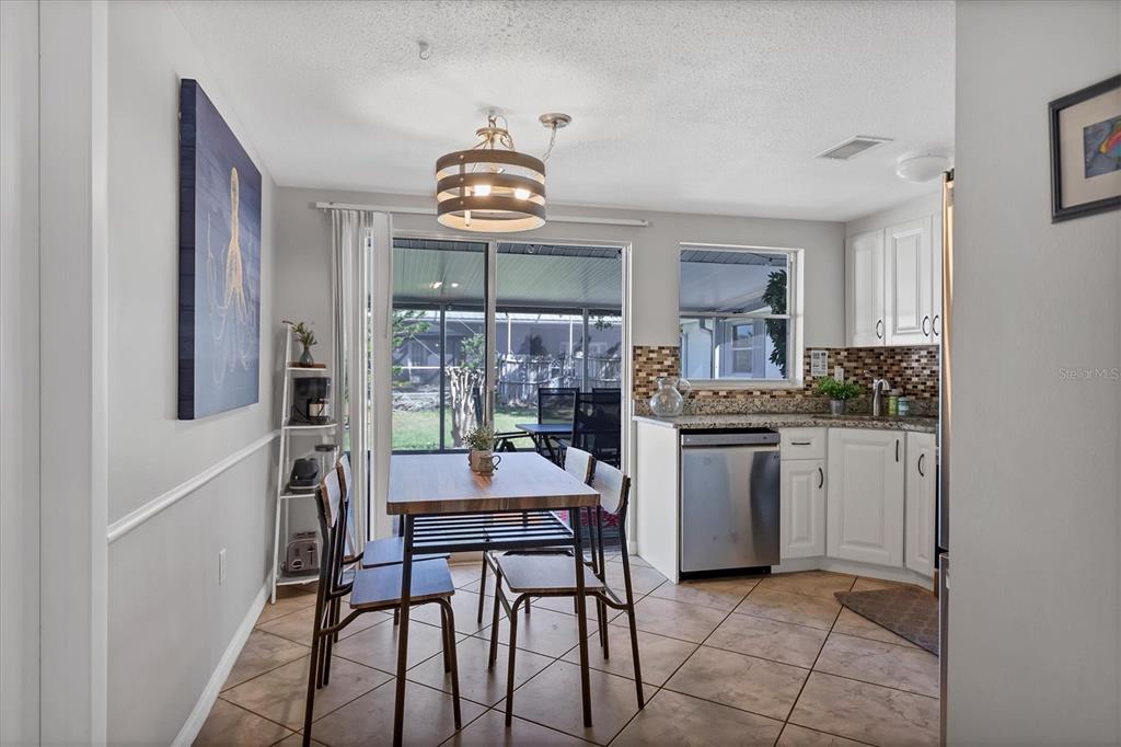 2323 Doud Street Sarasota, FL 34231 - Photo 11 of 34 a kitchen with a refrigerator a stove cabinets and dining table