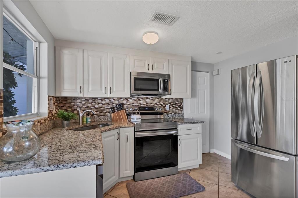 2323 Doud Street Sarasota, FL 34231 - Photo 14 of 34 a kitchen with granite countertop a stove sink and refrigerator
