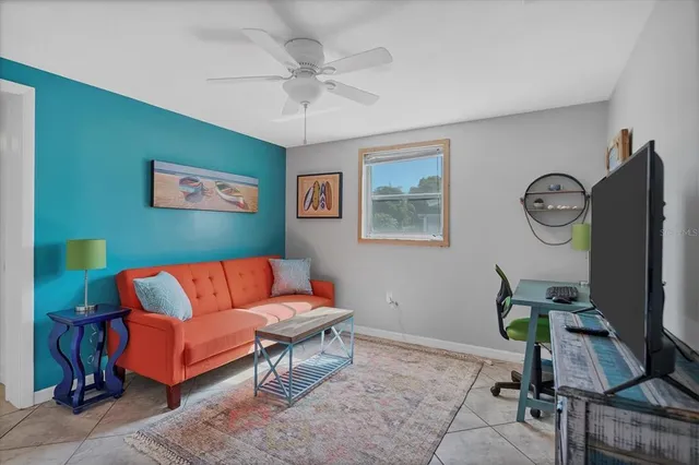 a living room with furniture a clock on wall and a window