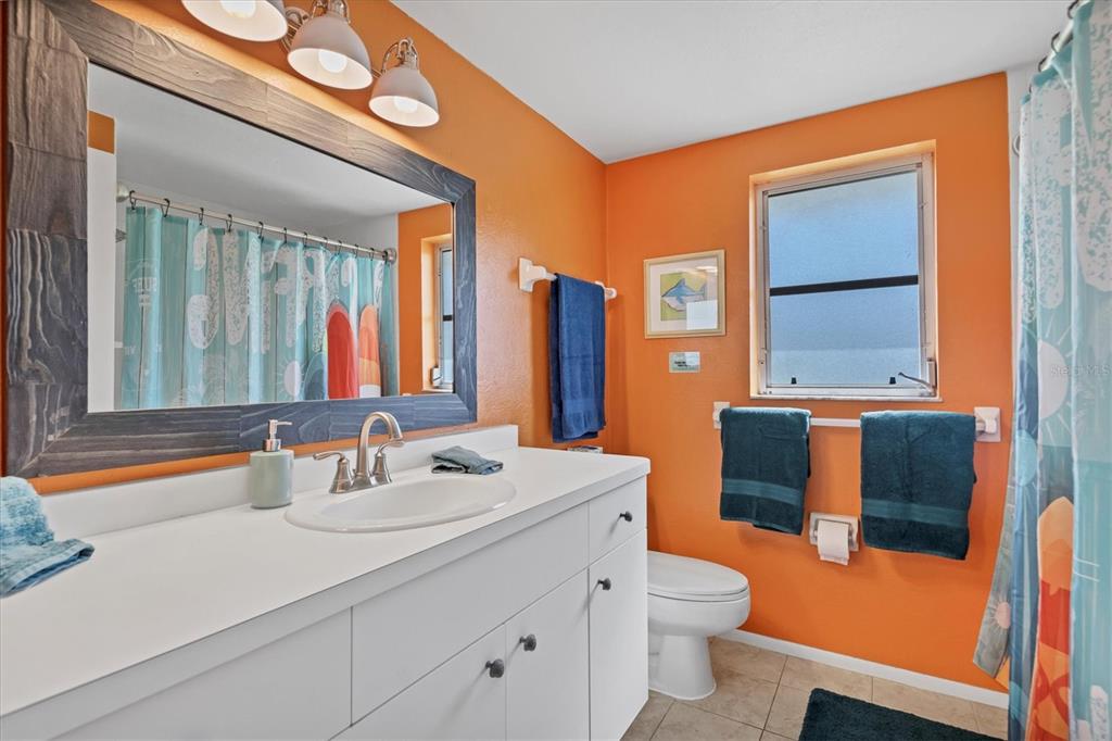 2323 Doud Street Sarasota, FL 34231 - Photo 22 of 34 a bathroom with a double vanity sink toilet and mirror