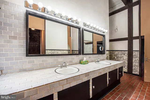 a bathroom with a granite countertop sink and a large mirror