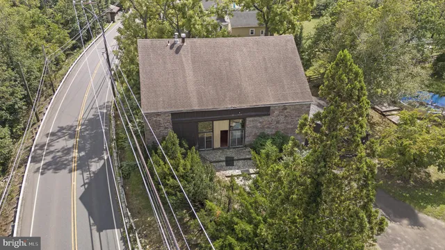 an aerial view of residential house with outdoor space and trees all around
