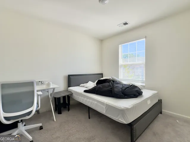 a bedroom with a bed and mirror