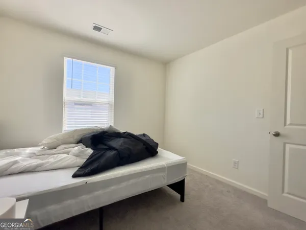 a bedroom with a bed and a chair