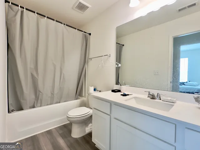a bathroom with a sink mirror and toilet