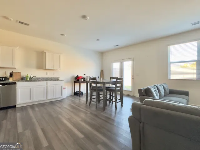 a living room with furniture wooden floor and a flat screen tv