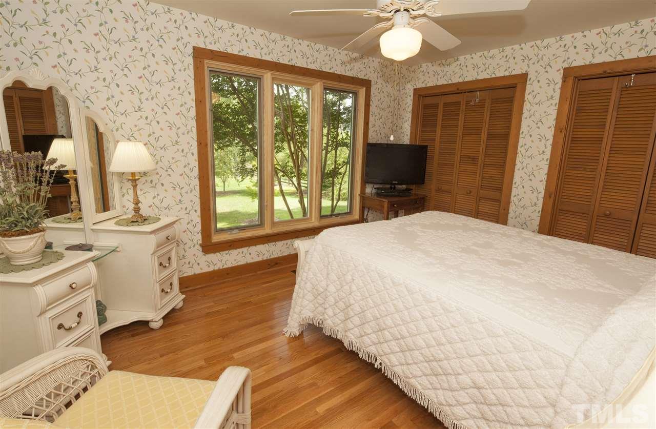 3529 Old Milburnie Road Raleigh, NC 27616 - Photo 14 of 25 a spacious bedroom with a bed and a chandelier