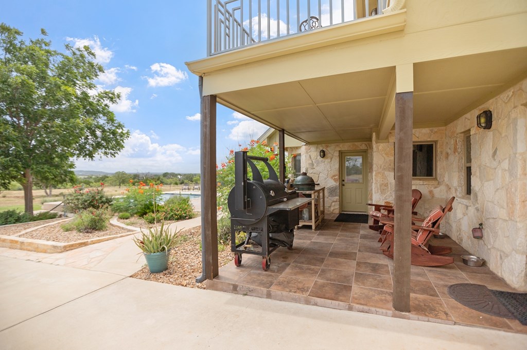 647 Funf Kinder Road Fredericksburg, TX 78624 - Photo 19 of 100 a view of a patio with a table and chairs and potted plants